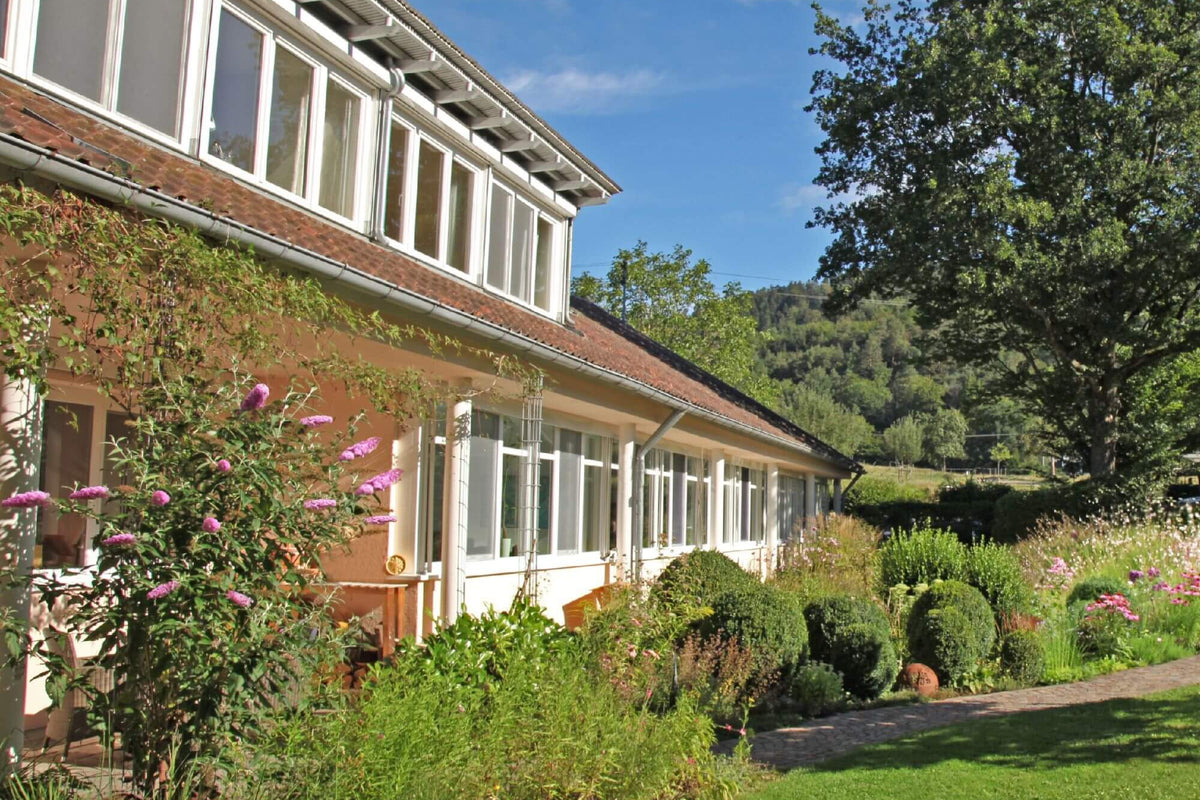 Gebäude der BERND WOLF Schmuckmanufaktur in naturnaher Umgebung. Das Bild steht für den Einsatz erneuerbarer Energien und nachhaltige Produktion mit Solarstrom.