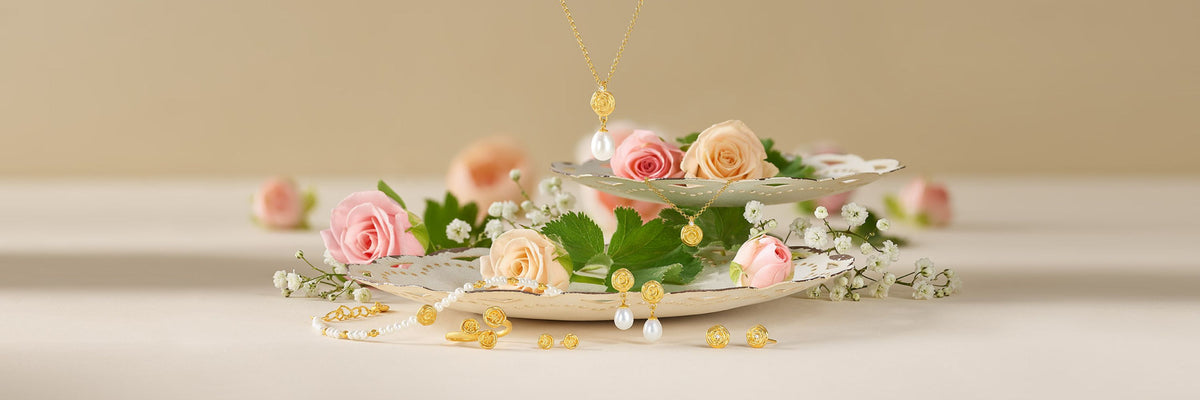 Goldener Brautschmuck mit Perlen, Halskette, Ohrringen und Armband zwischen rosa Rosen
